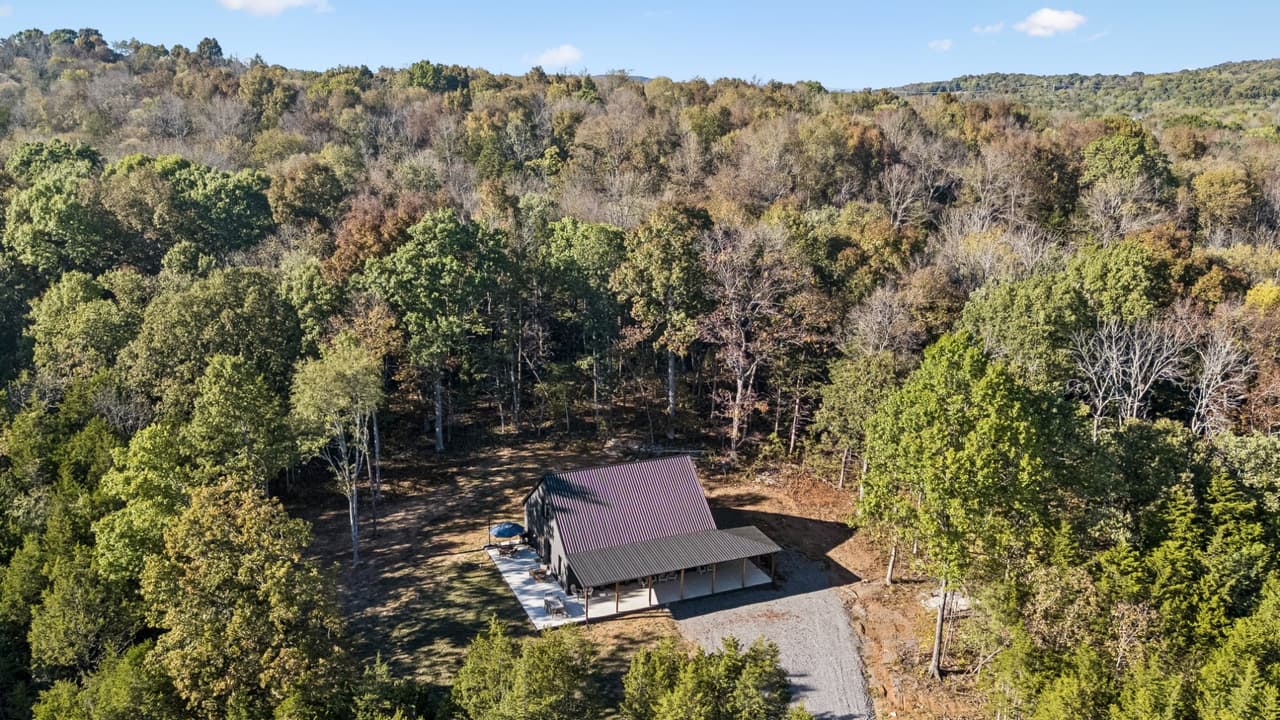 Aerial view of The Salem House in a clearing surrounded by autumn-colored woodland.